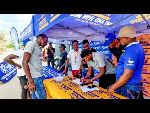 Supreme Betting promotional stand with staff helping customers outdoors